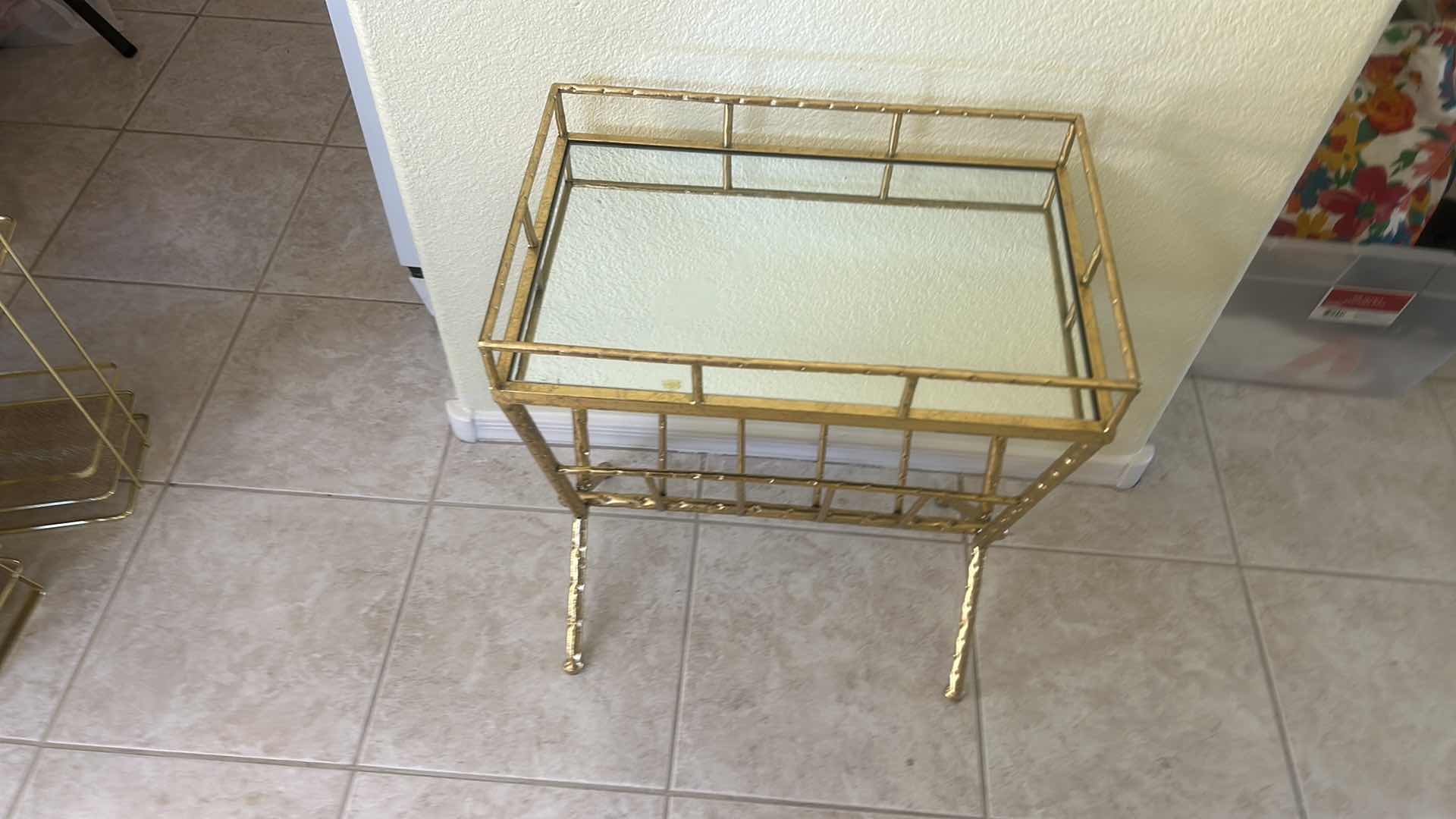 Photo 1 of VINTAGE-STYLE GOLD METAL MAGAZINE RACK FEATURING GLASS PANELS, A DECORATIVE HAMMERED FINISH, AND AN OPEN STORAGE COMPARTMENT 18 1/4“ x 12“ x H23“ $60