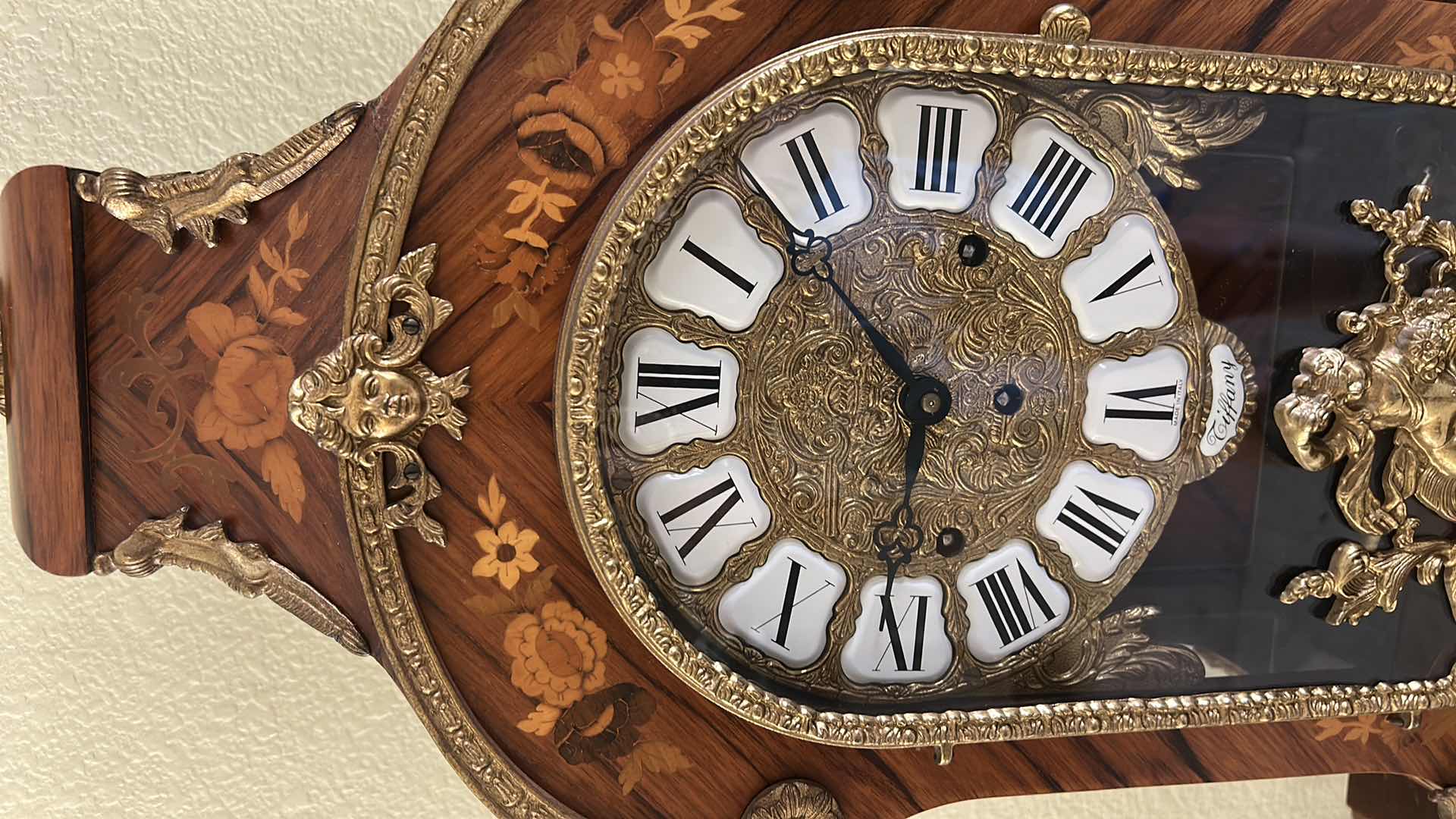 Photo 1 of TIFFANY MADE IN ITALY - FRENCH STYLE VERSAILLES CLOCK FEATURES AN ORNATE GILDED METAL CASE WITH ELABORATE SCROLLWORK, FLORAL MOTIFS, AND A DECORATIVE FINIAL. MATCHING PEDESTAL 14 1/2“ x 6 1/4“ x H31“ PEDESTAL16 1/2” x 9 1/2” x H 44 1/2” TOTAL HEIGHT, INCL