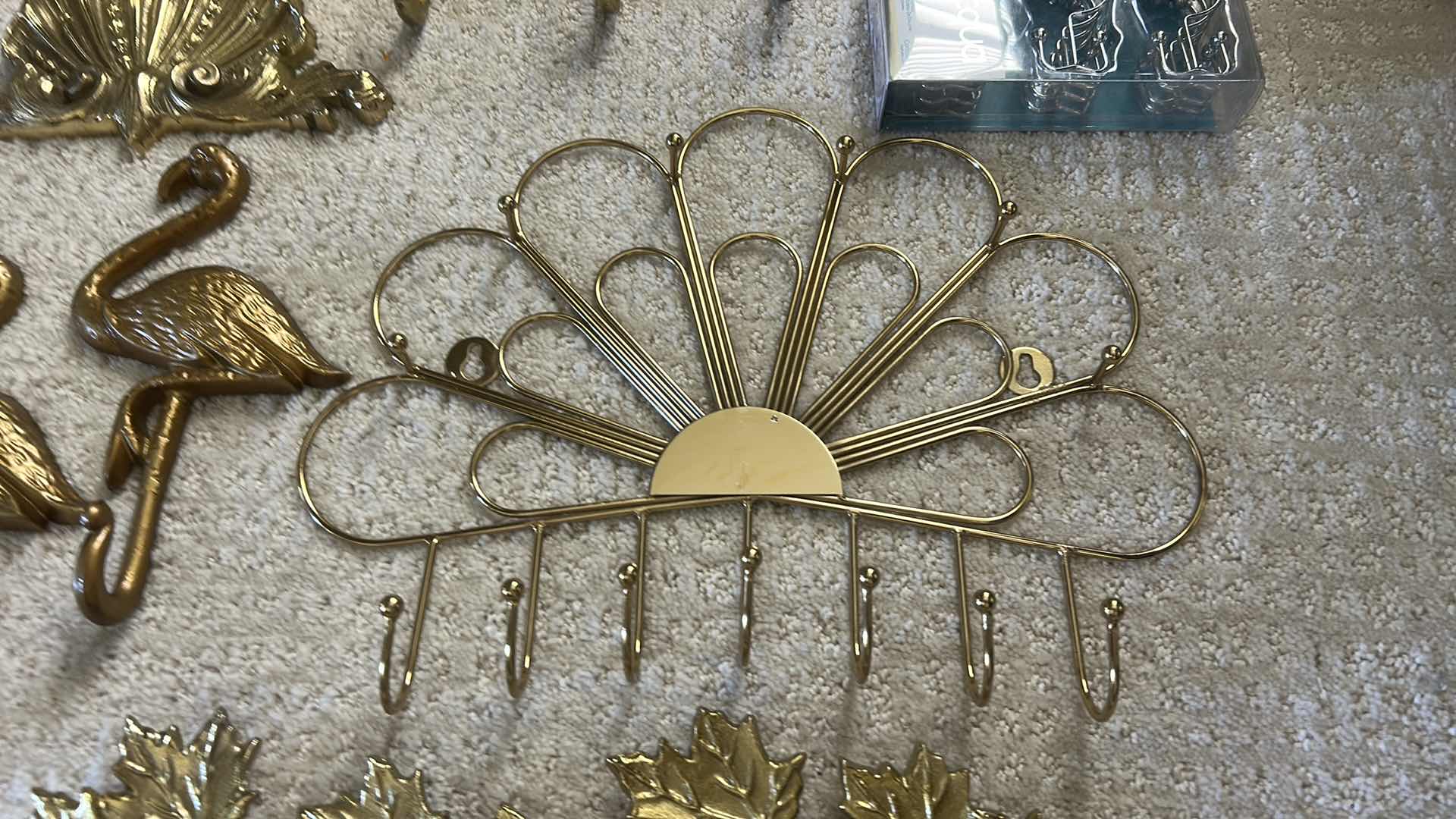Photo 1 of GOLD-COLORED METAL WALL RACKS FEATURING HOOKS FOR ORGANIZING ITEMS.