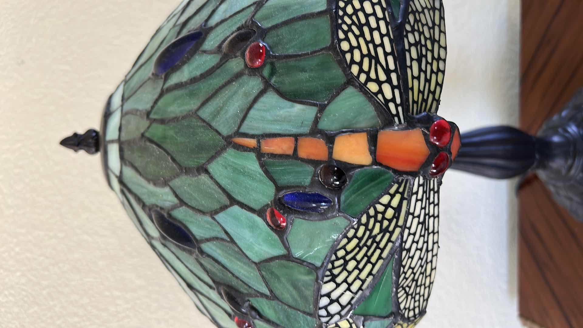 Photo 1 of DRAGONFLY TABLE LAMP FEATURES A GREEN STAINED GLASS SHADE WITH RED AND BLUE JEWELED INSERTS, RESEMBLING STYLES OFFERED BY WAREHOUSE OF TIFFANY. H19”