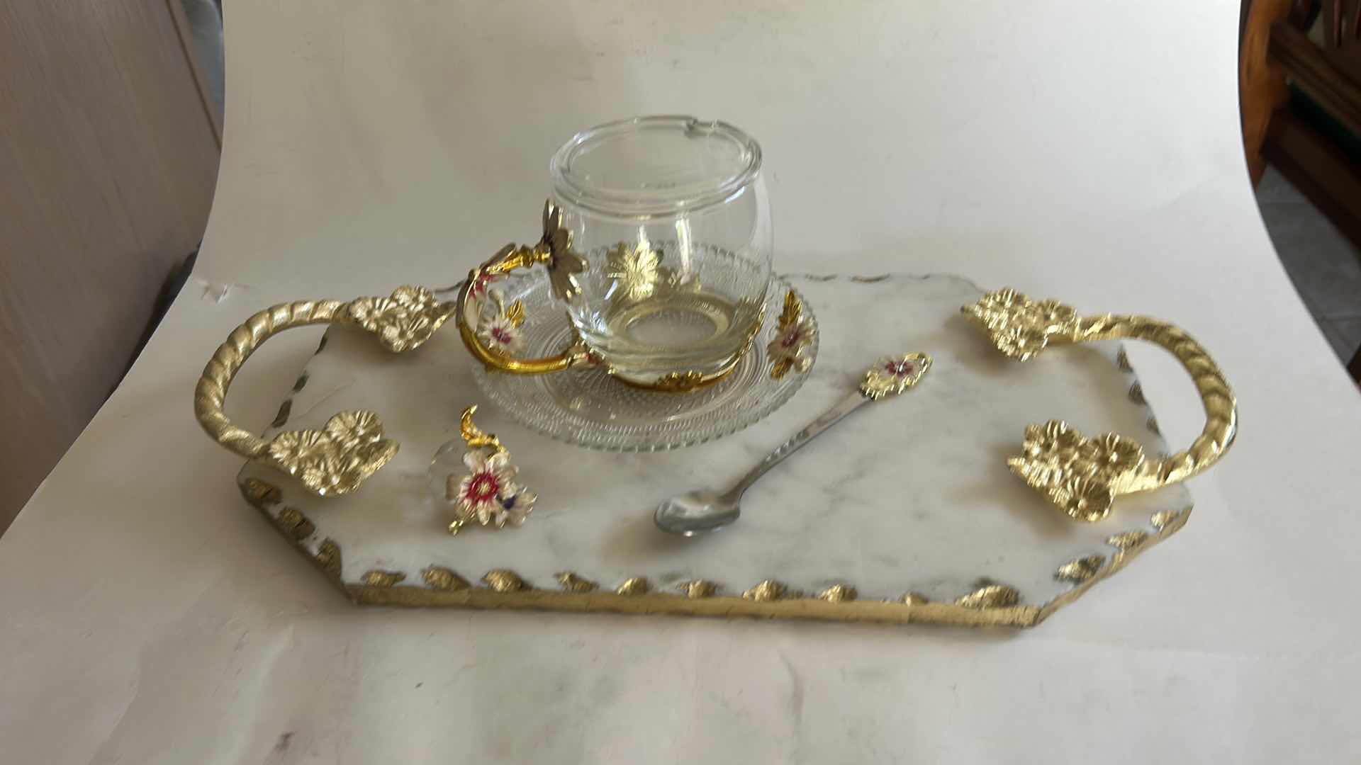 Photo 1 of VINTAGE-STYLE ENAMEL GLASS FLORAL TEA CUP FEATURES INTRICATE 3D BUTTERFLY AND ROSE DETAILS ON THE HANDLE AND LID & HANDMADE SERVING TRAY FEATURES A WHITE MARBLE BASE ACCENTED WITH INTRICATE GOLD-FINISHED METAL HANDLES.