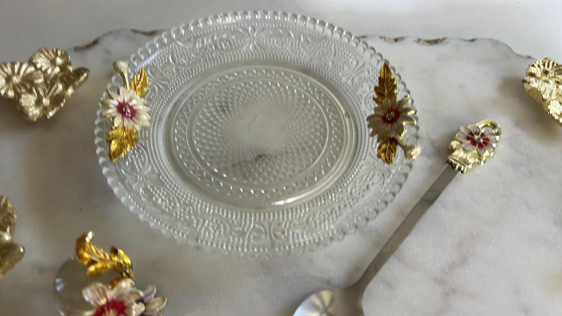 Photo 1 of VINTAGE-STYLE ENAMEL GLASS FLORAL TEA CUP FEATURES INTRICATE 3D BUTTERFLY AND ROSE DETAILS ON THE HANDLE AND LID & HANDMADE SERVING TRAY FEATURES A WHITE MARBLE BASE ACCENTED WITH INTRICATE GOLD-FINISHED METAL HANDLES.