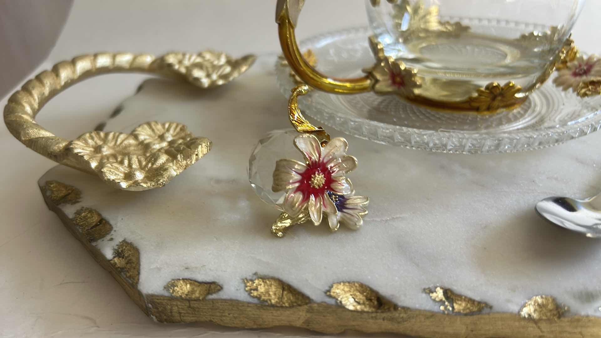 Photo 1 of VINTAGE-STYLE ENAMEL GLASS FLORAL TEA CUP FEATURES INTRICATE 3D BUTTERFLY AND ROSE DETAILS ON THE HANDLE AND LID & HANDMADE SERVING TRAY FEATURES A WHITE MARBLE BASE ACCENTED WITH INTRICATE GOLD-FINISHED METAL HANDLES.