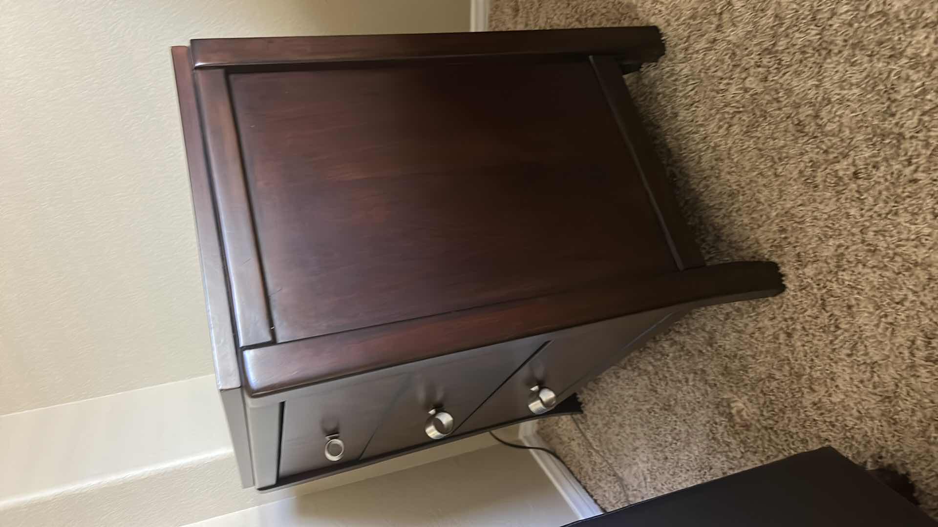 Photo 1 of DARK WOOD THREE-DRAWER NIGHTSTAND W HIGH-GLOSS FINISH BURLED WOOD VENEER DRAWER FRONTS & POLISHED METAL KNOBS.
