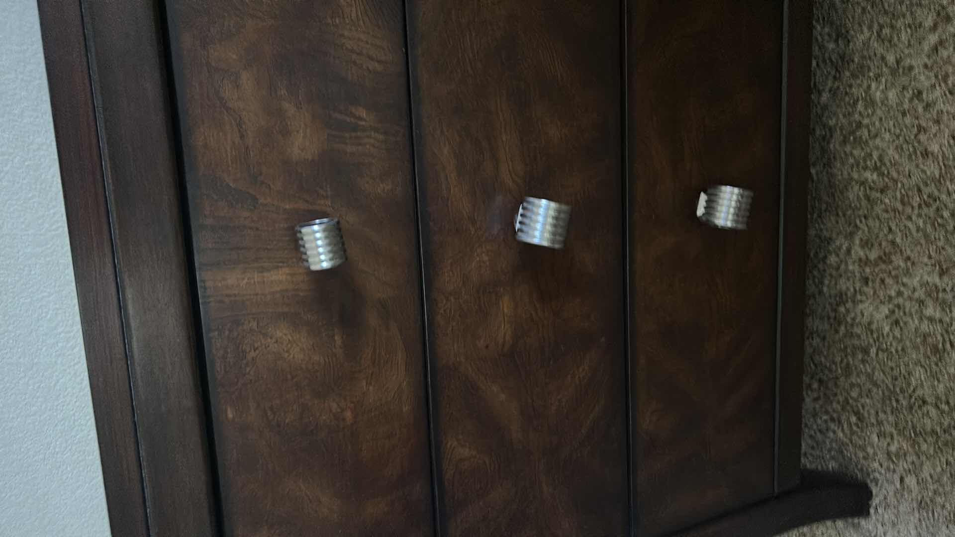 Photo 1 of DARK WOOD THREE-DRAWER NIGHTSTAND W HIGH-GLOSS FINISH BURLED WOOD VENEER DRAWER FRONTS & POLISHED METAL KNOBS.