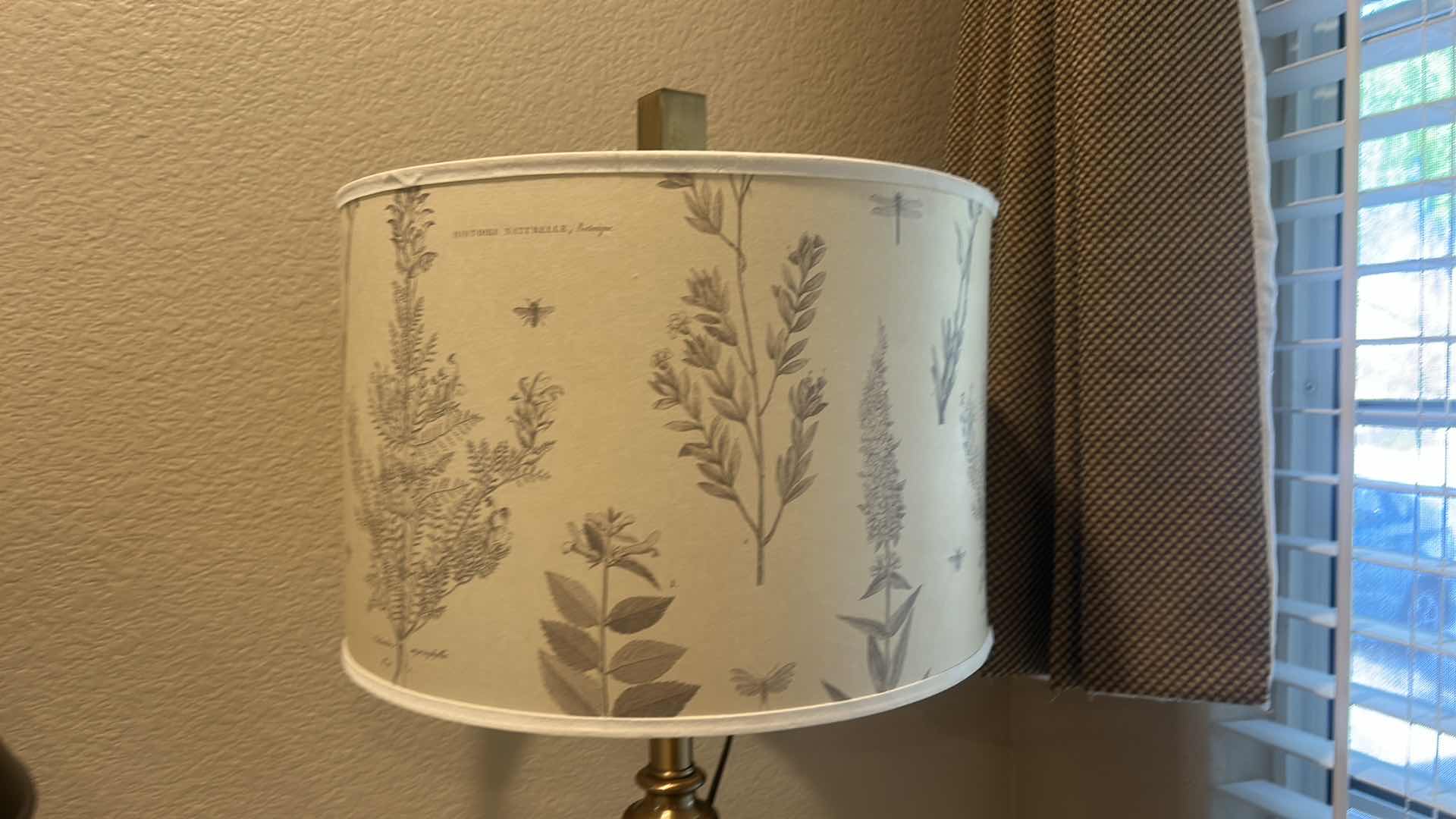 Photo 1 of TABLE LAMP FEATURES A WHITE CERAMIC VASE BODY AND A BOTANICAL PATTERNED SHADE. H34”