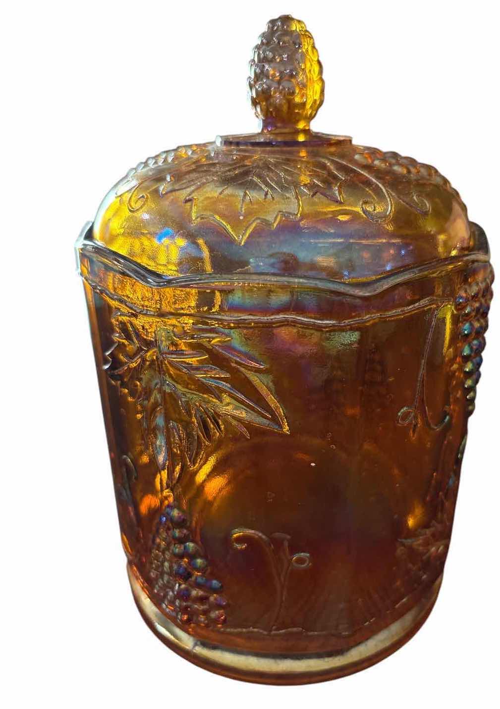 View 1 of IRIDESCENT CARNIVAL GLASS LIDDED CANISTER WITH EMBOSSED GRAPE & VINE DESIGN H8.5”
