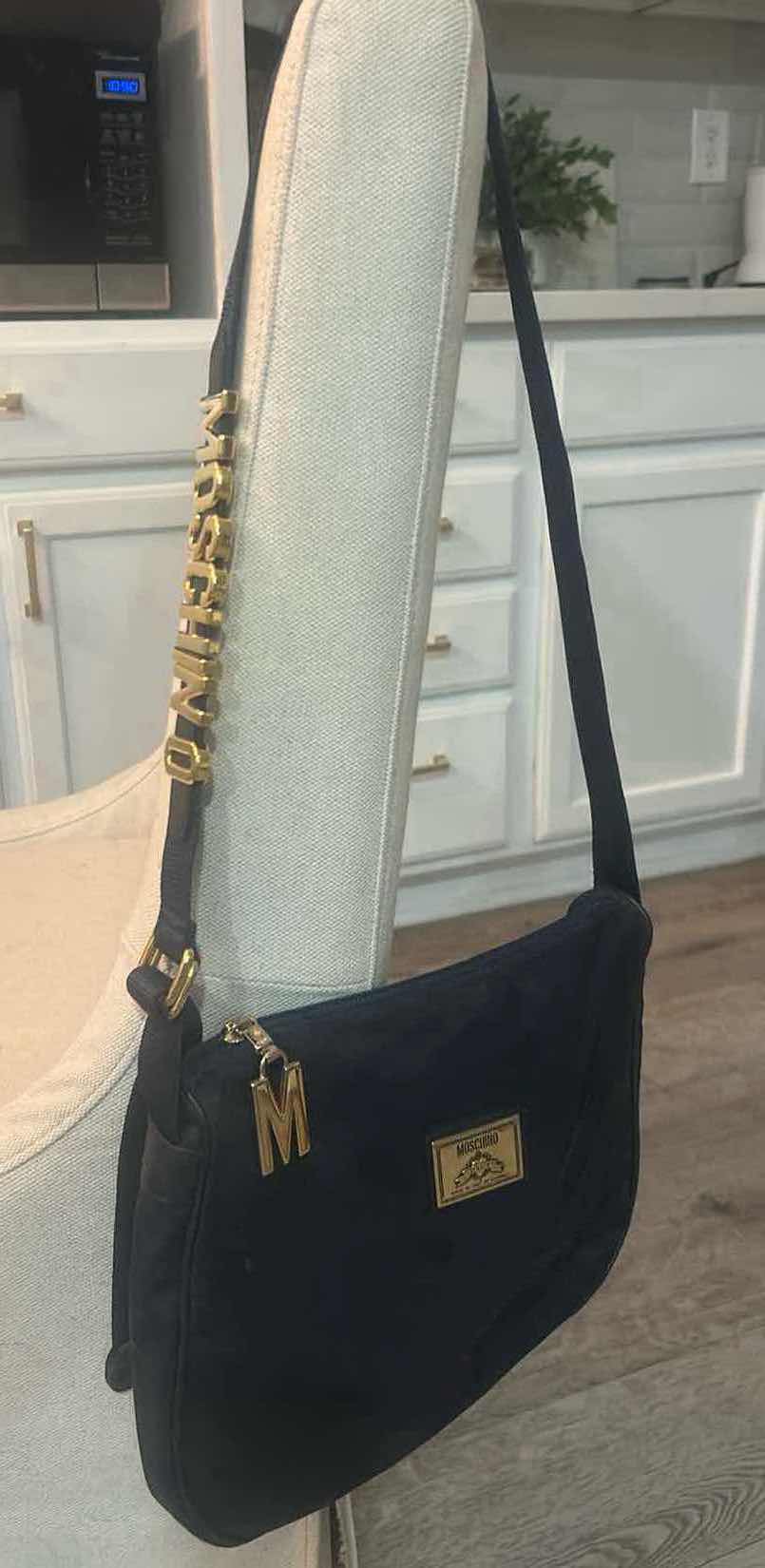 Photo 1 of VINTAGE BLACK NYLON MOSCHINO SHOULDER BAG WITH BRANDS SIGNATURE BLOCK LETTERING ALONG THE STRAP