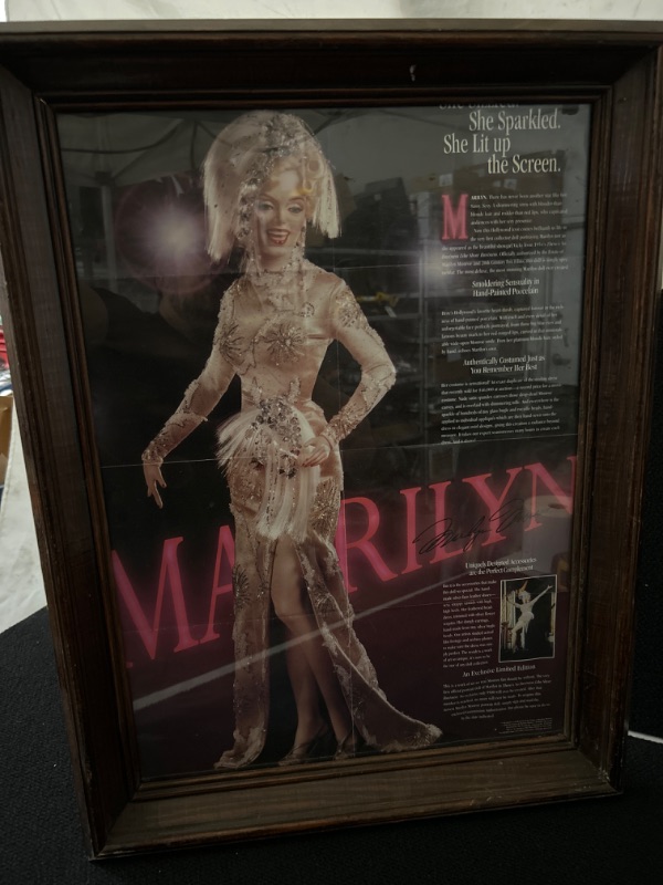 Photo 1 of Framed Marilyn Monroe doll advertisement. The advertisement has been folded and has creases. measures 19 x 25 inches 