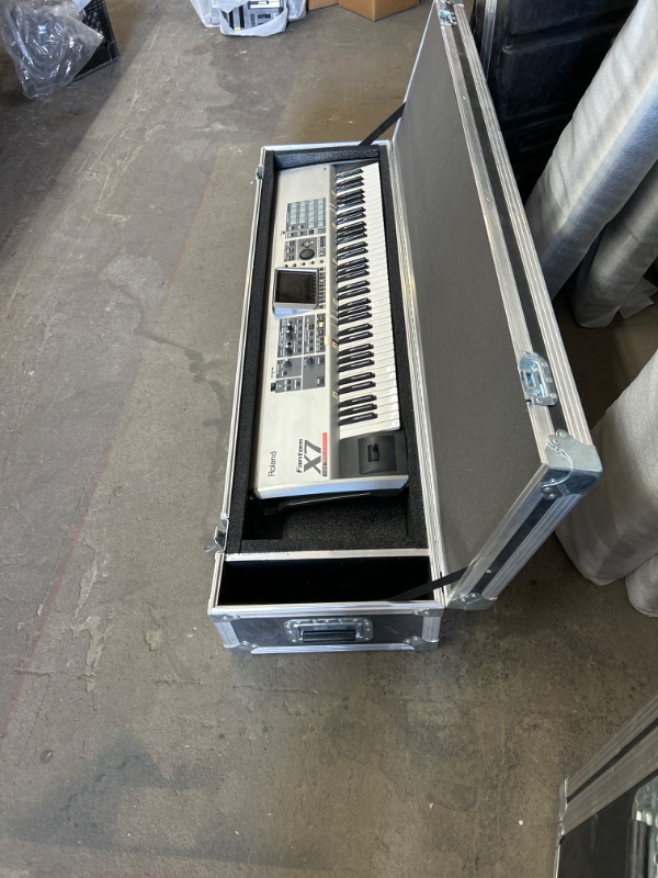 Photo 1 of Roland Fanton X7 76 key workstation keyboard plugged in powers up no further testing missing knob in heavy duty road case with wheels measures 63 x 16 x 11 inches