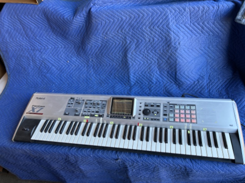 Photo 1 of Roland Fanton X7 76 key workstation keyboard plugged in powers up no further testing missing knob in heavy duty road case with wheels measures 63 x 16 x 11 inches