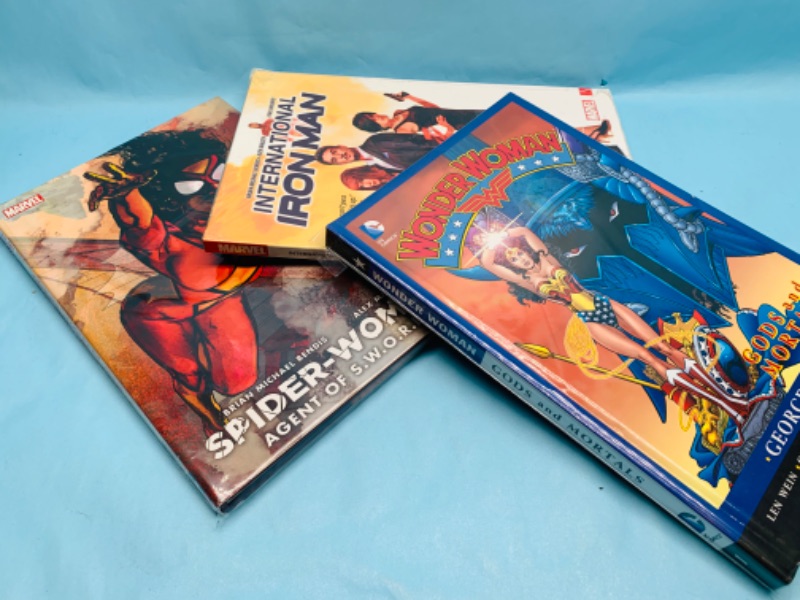 Photo 1 of 278910…3 hardcover books- wonder woman, spider woman, and Iron Man in plastic sleeves