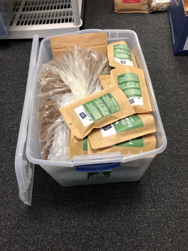 Photo 1 of plastic bin full of dog treats and dog food sold as is treats expired May 11 2021 dog food has no expiration date on bags