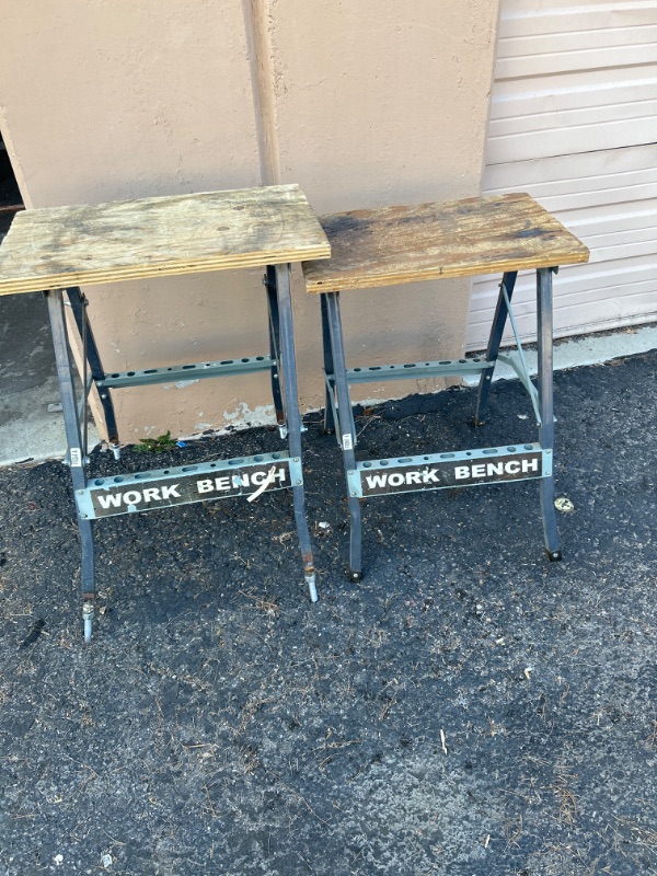 Photo 1 of two folding work benches one has bolts welded on the legs