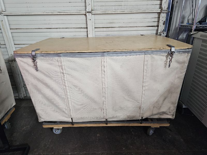 Photo 1 of White Canvas Lockable Hamper Truck (55"L x35"W x37"H) is ideal for storing and protecting material in process, finished goods, musical instruments, theatre costumes or sporting equipment. Solid one piece wood lid with padlock hasp protects valuable cargo 