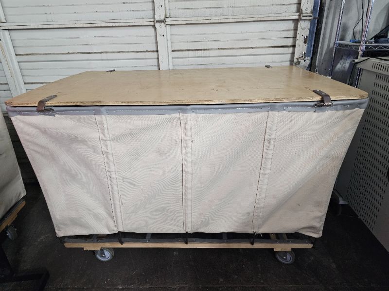 Photo 3 of White Canvas Lockable Hamper Truck (55"L x35"W x37"H) is ideal for storing and protecting material in process, finished goods, musical instruments, theatre costumes or sporting equipment. Solid one piece wood lid with padlock hasp protects valuable cargo 