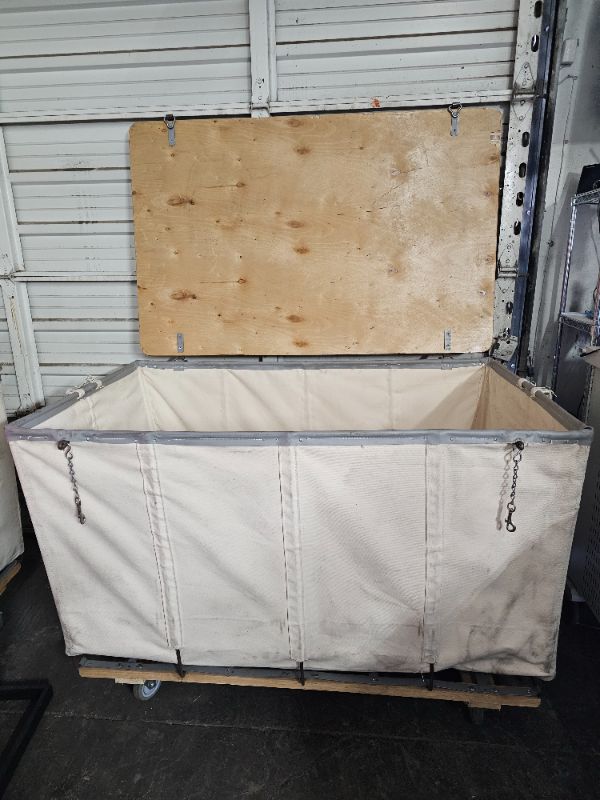 Photo 1 of White Canvas Lockable Hamper Truck (55"L x35"W x37"H) is ideal for storing and protecting material in process, finished goods, musical instruments, theatre costumes or sporting equipment. Solid one piece wood lid with padlock hasp protects valuable cargo 