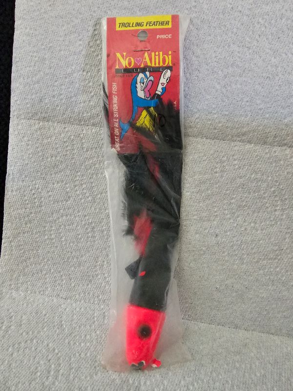 Photo 1 of No Alibi, Trolling Feather Lure, Black/Red Skirt, 6oz Head
-Chip on nose [see photos for details]