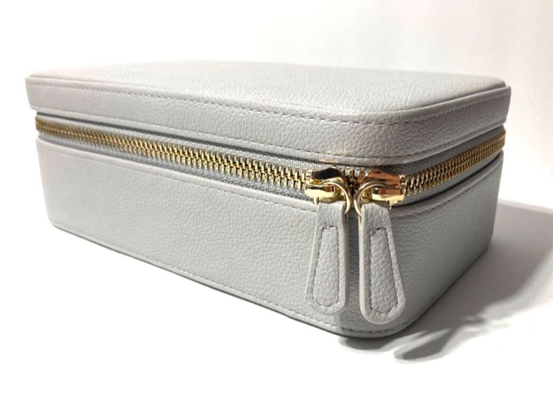 Photo 1 of A spacious jewelry GREY case that can store a variety of jewelry pieces, keeping them secure and organized within multiple compartments, and a drawstring pouch. Ideal for a long trip or a short getaway. Removable drawstring pouch - Necklace Hooks - Elasti
