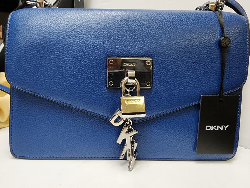 Photo 1 of DKNY Elissa Small Shoulder Flap BlueSliver. A playful charm locks up contemporary-chic style with this leather Elissa shoulder bag from DKNY.
Small sized bag; 10-1/2"W x 7-1/2"H x 3"D; (width is measured across the bottom of handbag); 1.75 lbs. approx. we