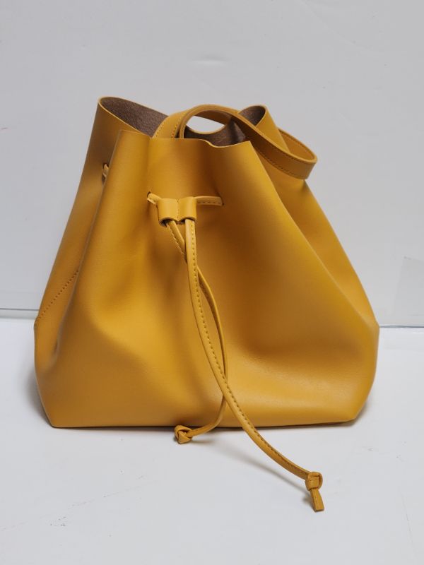 Photo 1 of Bucket bag in grained faux leather with one handle and a drawstring at top. Size 5 1/2 x 11 x 11 1/4 in.