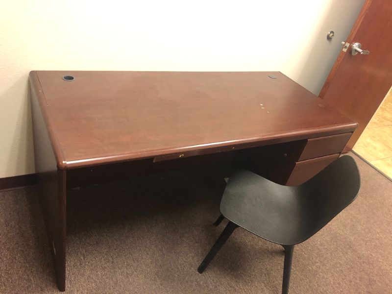 Photo 1 of Oversized office desk with black chair.