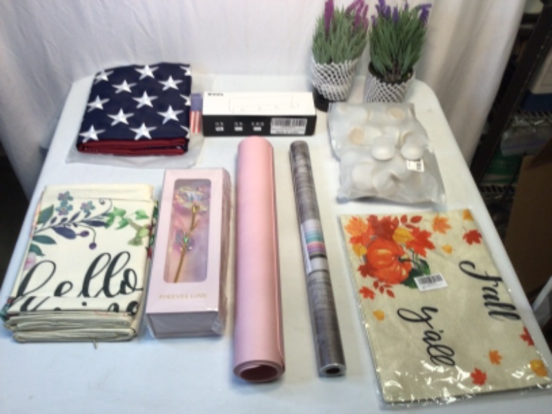 Photo 1 of Bundle of Assorted Home Items- 1) 3 x 5 American Flag 2) Two Artificial Plants 3) Mail and Key Holder 4) Outdoor Fall Yard Flag (2) 5) 4 Piece Spring Couch Cushion Covers  (2 Sets) 6) Roll of Contact Paper 7) Pink Large Computer/Mouse Pad 8) Decorative Me