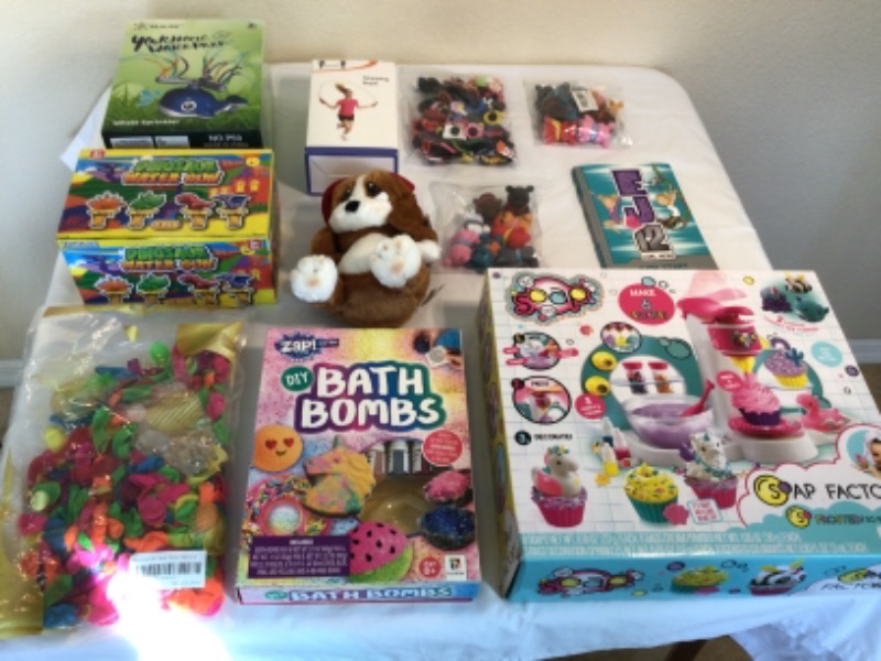 Photo 1 of Small Bundle of Children's Toys Items- 1) Whale Water Sprinkler 2) Dinosaur Water Guns 3) Jump Rope 4) Sad Sam Plush Dog 5) 3 Packages Small Figurines 6) DIY Bath Bombs  7) Diy Soap Factory 8) Water Balloons