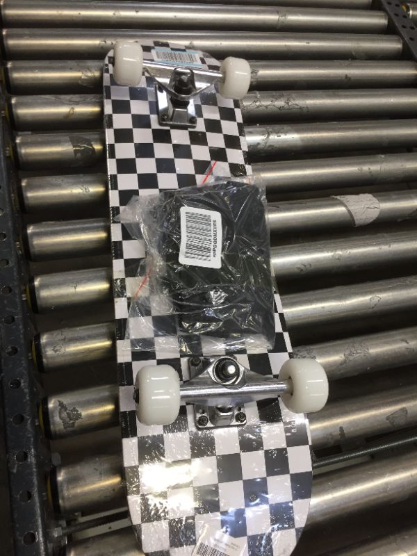 Photo 1 of BLK/WHT CHECKERED 31" SKATEBOARD, TRUCKS LOOSE . WRAPPED IN PLASTIC BUT SLIGHT DINGS/SCRACTHES 
