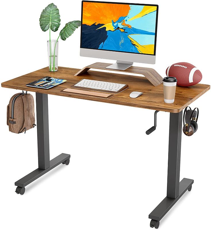 Photo 1 of FAMISKY Crank Adjustable Height Standing Desk, 40 x 24 Inches Manual Stand up Desk, Sit Stand Workstation for Home Office with Handle and Splice Board, Black Frame/Walnut Top

