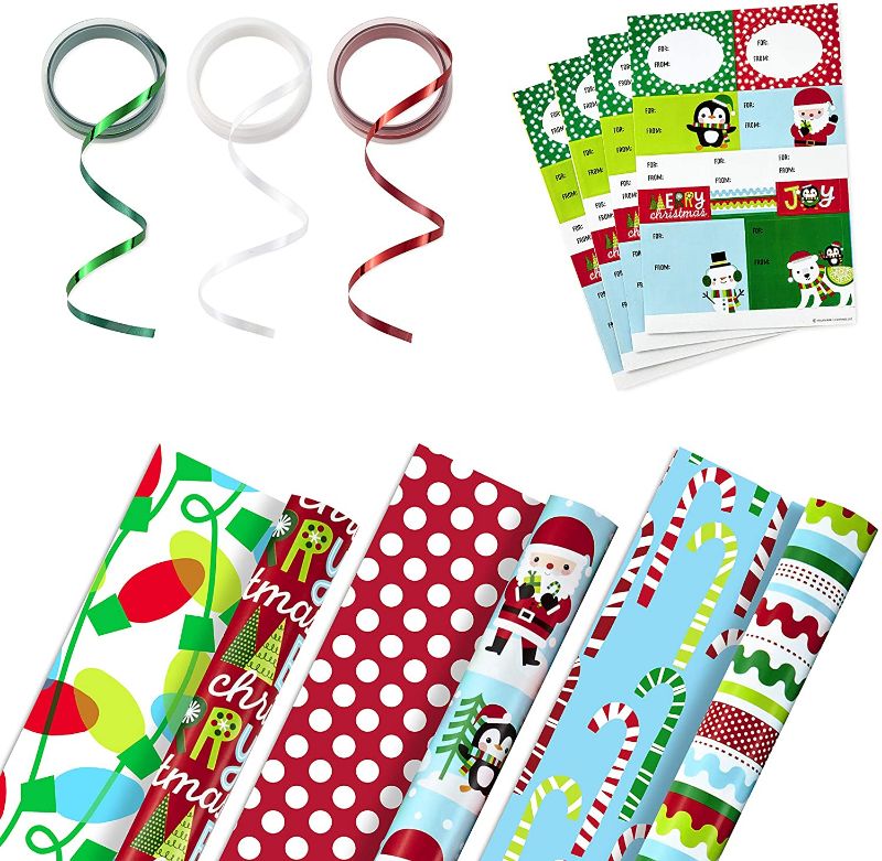 Photo 1 of Hallmark Reversible Christmas Wrapping Paper Set with Ribbon and Gift Tag Stickers (3 Rolls of Wrapping Paper and Ribbon; Santa, Penguins, Stripes, Dots)

//used 
