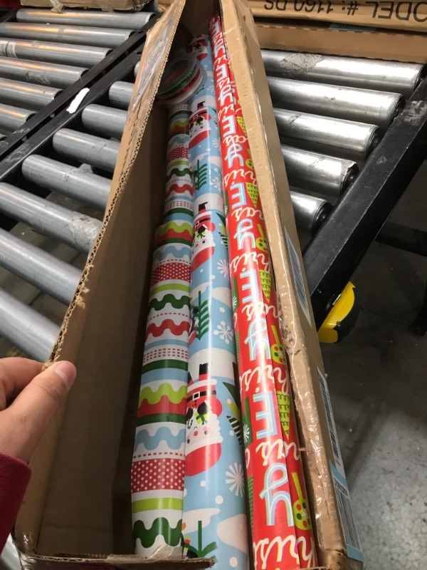 Photo 2 of Hallmark Reversible Christmas Wrapping Paper Set with Ribbon and Gift Tag Stickers (3 Rolls of Wrapping Paper and Ribbon; Santa, Penguins, Stripes, Dots)

//used 
