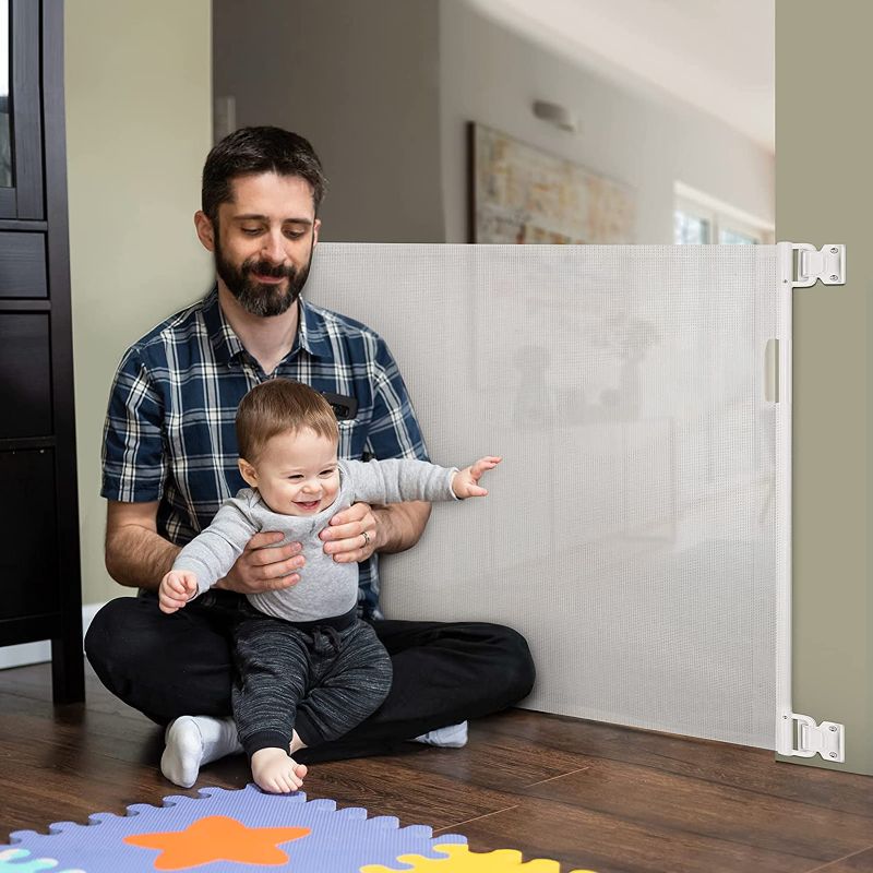 Photo 1 of Retractable Baby Gate, Momcozy Mesh Safety Gate for Babies and Pets, Extra Wide Safety Baby Gate 33.7" Tall, Extends to 55" Wide, Pet Dog Gate for doorways, Stairs, Hallways, Indoor/Outdoor (White)
