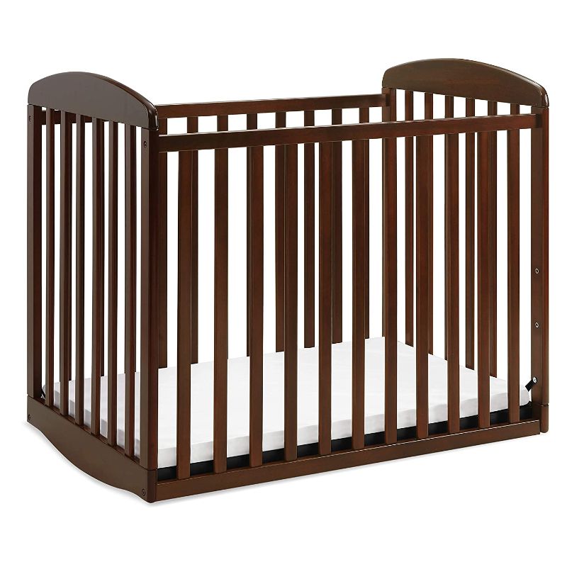 Photo 1 of Davinci Alpha Mini Rocking Crib in Espresso, Removable Wheels, Greenguard Gold Certified
