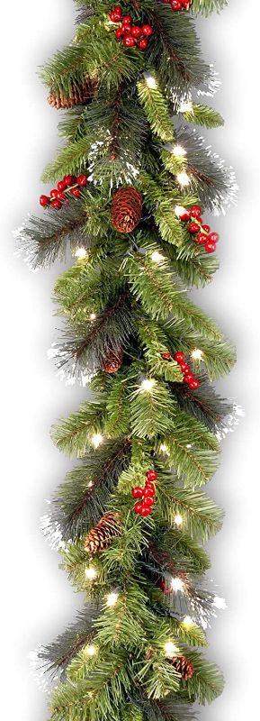 Photo 1 of National Tree Company Pre-Lit Artificial Christmas Garland, Green, Crestwood Spruce, White Lights, Decorated with Pine Cones, Berry Clusters, Plug In, Christmas Collection, 9 Feet