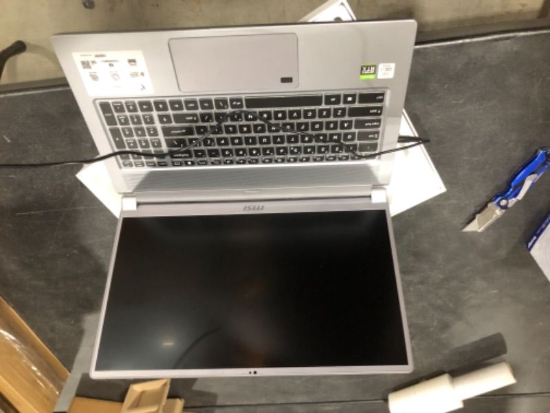 Photo 2 of MSI Laptop Intel Core i7 10th Gen 10875H (2.30 GHz) 16 GB Memory 512 GB NVMe SSD NVIDIA GeForce RTX 2070 Max-Q 17.3" Windows 10 Pro 64-bit  **DOES NOT TURN ON ** HAS A DENT ON THE TOP, also missing ram module, For parts only