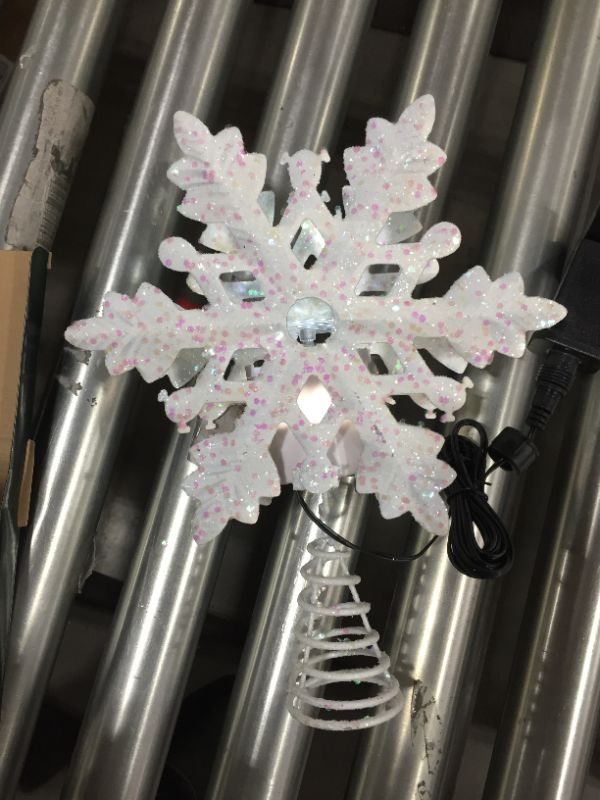 Photo 2 of Christmas Tree Topper Lighted with Built-in Led Rotating Snowflake Projector Lights, 9.6” Hollowed Tree Topper with Silver Spangles Plug In for Indoor Home Xmas New Year Party Holiday Night Tree Decor
