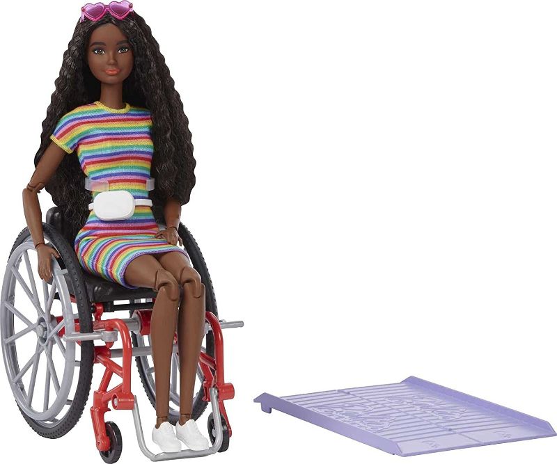 Photo 1 of Barbie Fashionistas Doll #166 with Wheelchair & Crimped Brunette Hair Wearing Rainbow-Striped Dress, White Sneakers, Sunglasses & Fanny Pack, Toy for Kids 3 to 8 Years Old
