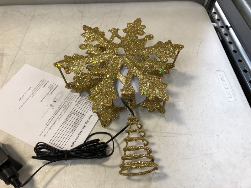 Photo 2 of Christmas Tree Topper with 3D Snowflake Projector Lights, 11.6" Snowflake Tree Topper Light Decorations, Indoor Outdoor Fantastic Rotating Projector Lights for New Year Holiday Christmas Tree (Gold)
