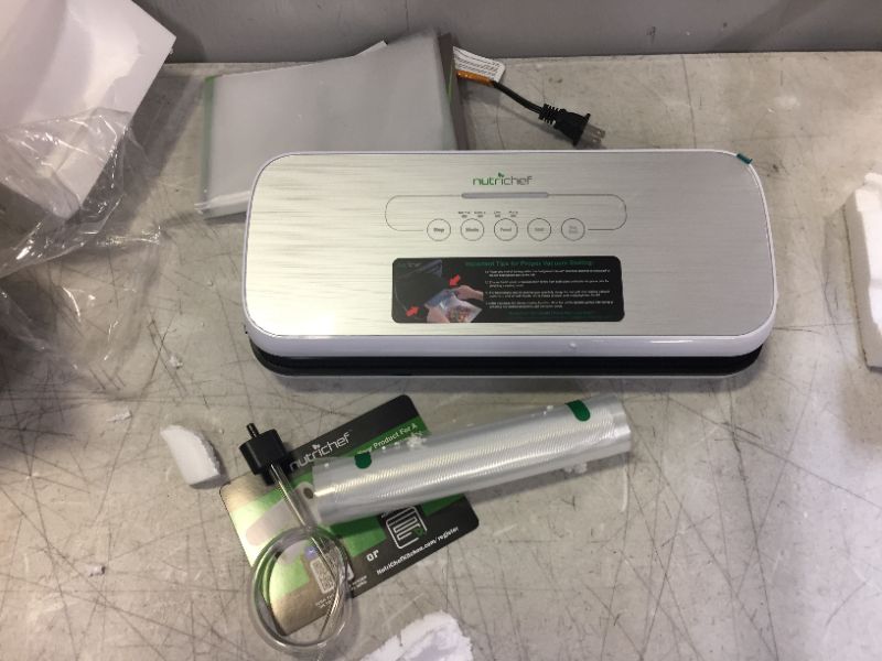 Photo 1 of NutriChef PKVS Sealer | Automatic Vacuum Air Sealing System Preservation w/Starter Kit | Compact Design | Lab Tested | Dry & Moist Food Modes | Led Indicator Lights, 12", Silver
