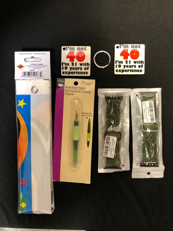 Photo 1 of Assorted items, 2 key chains, outdoor indoor party banner, small inseam ripper tool, 2 watch bands