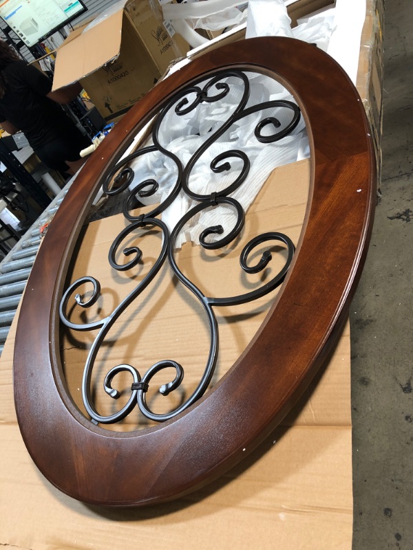 Photo 2 of (CRACKED TABLE LEG INSERTION; SCRATCHED/DENTED) Signature Design by Ashley Nestor Traditional Oval Coffee Table with Beveled Glass Top, Scrollwork Underlay and 1 Fixed Shelf, Dark Brown, 34.25"D x 48"W x 20.25"H

