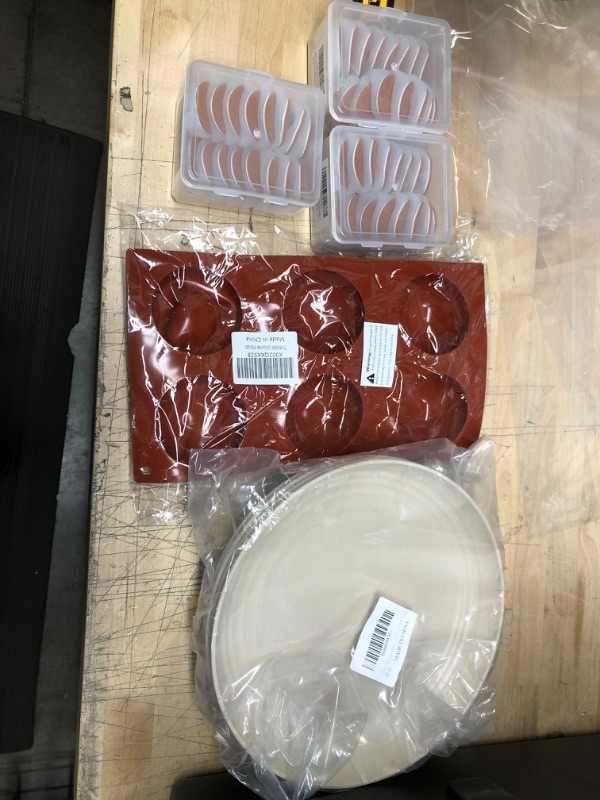 Photo 1 of **NON REFUNDABLE**
BUNDLE OF ASSORTED HOME GOODS .  SILICON COOKING MOLDS, PLATES , CHAIR LEG PROTECTORS.

