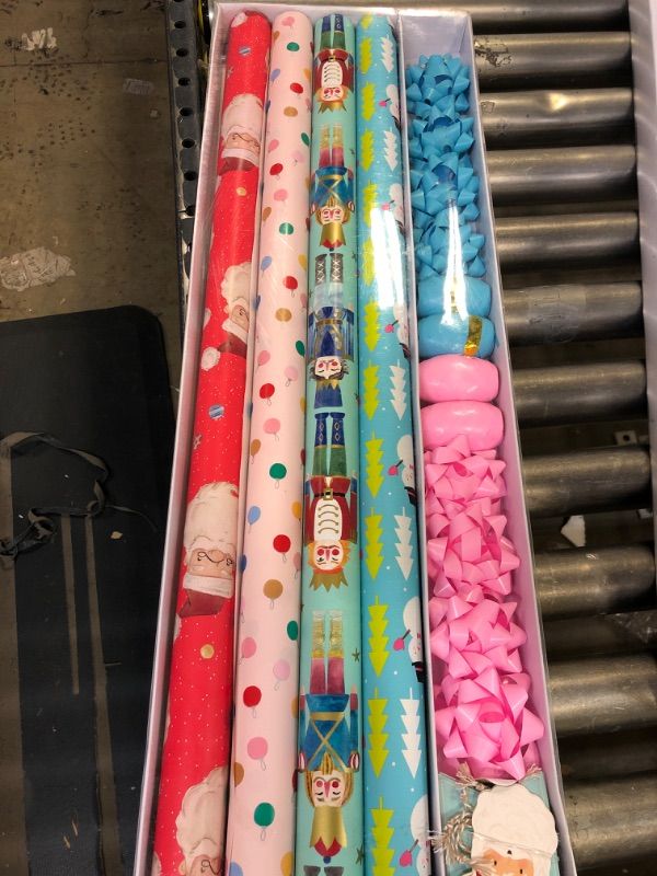 Photo 2 of Wrapping Paper, Christmas Wrapping Paper for Kids Boys, Girls, baby. 4 Cute Designs Including Santa, Christmas Lights, Snowman, Nutcracker. Includes Decorative Flowers, Ribbons, Labels. Each Roll of Gift Wrap Paper Measures 27.5 In X 13 ft
