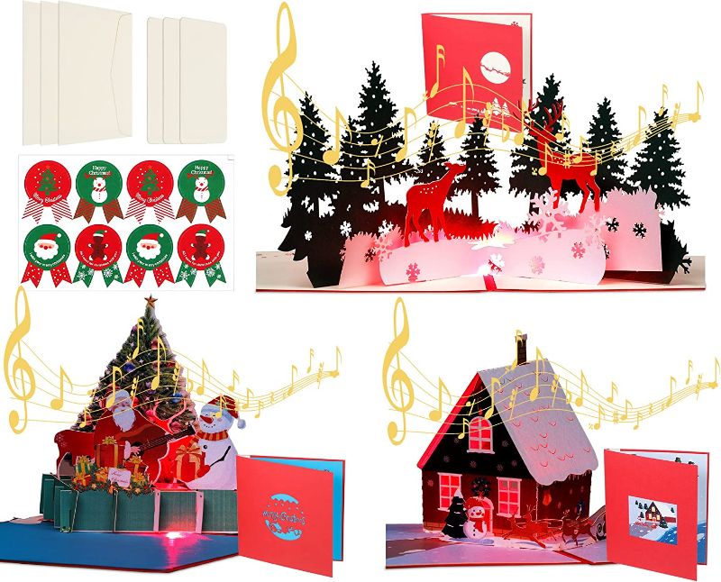 Photo 1 of 3 Pieces Musical Christmas Pop up Card with Lights Christmas 3D Greeting Cards Christmas Tree House Elk Pop up Cards with 8 Pieces Christmas Stickers for Christmas Gift
