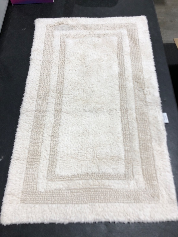 Photo 1 of 20 X 34 PERFORMANCE BATH MAT. CREAM COLORED. PRIOR USE. THREAD DAMAGE TO BOTTOM