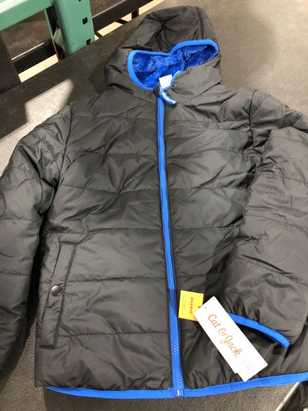 Photo 2 of  Black/Blue  Reversible Puffer Jacket from Cat and Jack™. Made from a water- and wind-resistant fabric, this boys' hooded puffer jacket ensures he stays nice and warm in chilly weather.   SIZE MEDIUM BOYS 