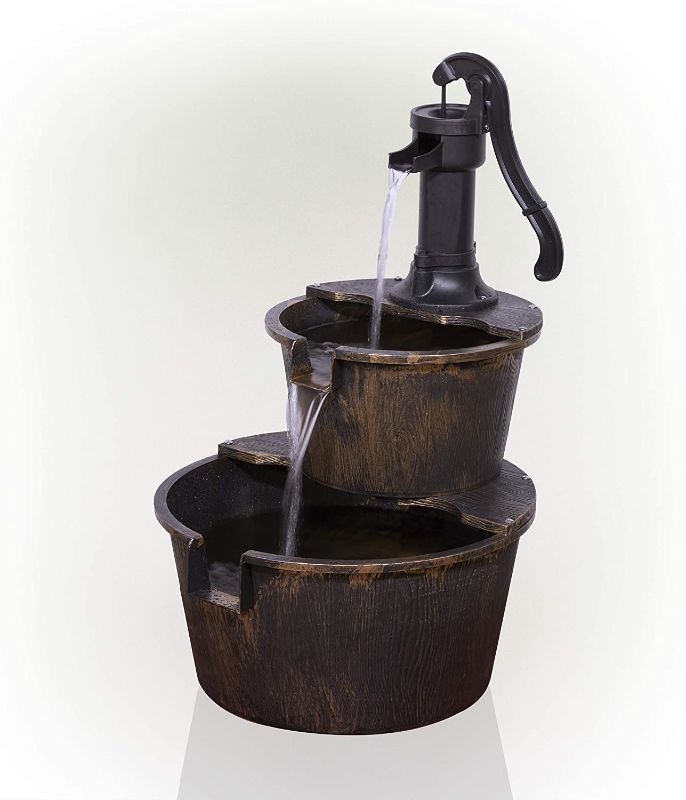 Photo 1 of Alpine Corporation 27" Tall 2-Tier Barrel and Pump Waterfall Fountain, Bronze Finish (USED, ITEM HAS WATERMARKS ON IT, AND HAS A DENT, UNABLE TO TEST)
