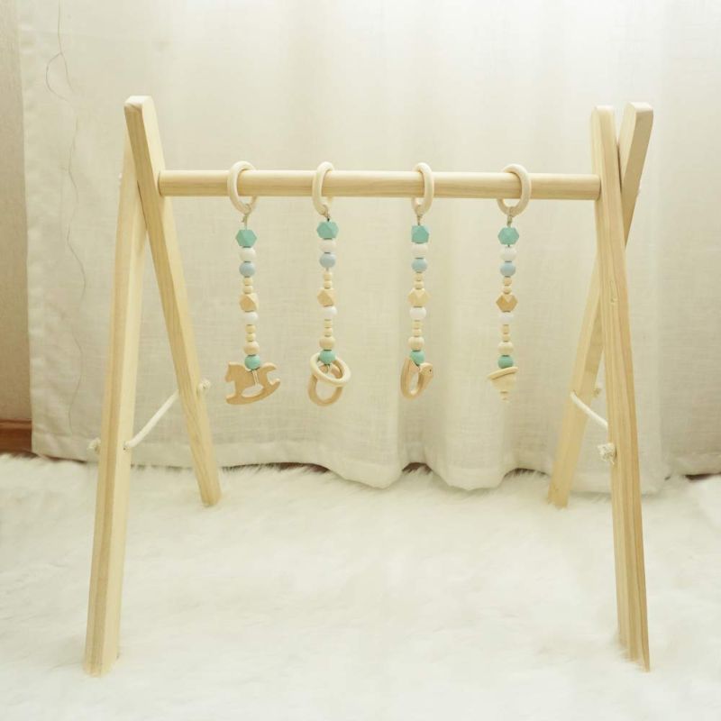 Photo 1 of Cynzia Baby Foldable Wooden Play Gym with 4 Theething Gym Toys Frame Activity Gym Natural Hanging Bar Newborn Gift Baby Girl and Boy Gym