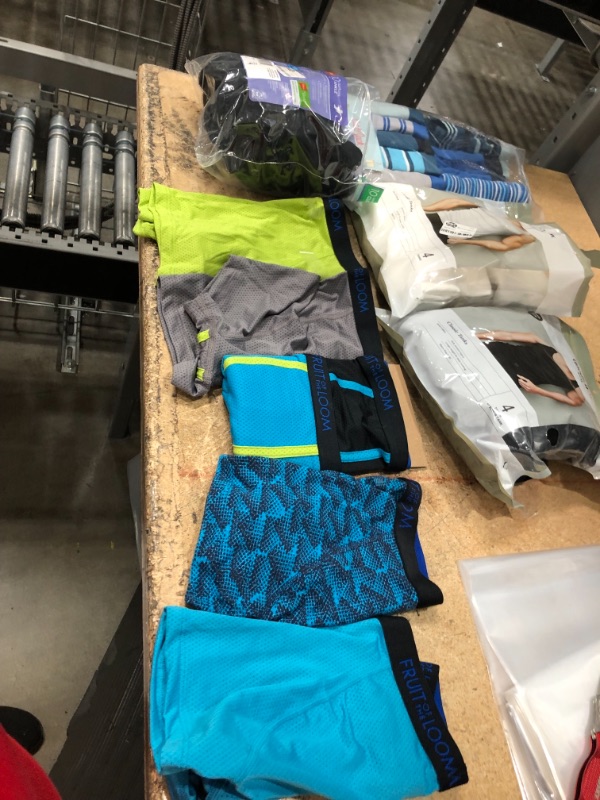 Photo 1 of bundle of boy and men clothes, sizes for underwears are small and medium and large  in kids, tank tops are size small(white), and large (black)